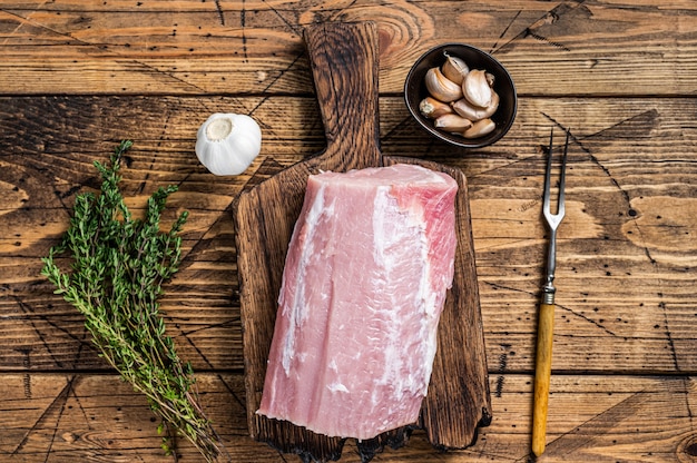 Filet de porc cru aux épices sur planche de bois. fond en bois. Vue de dessus.