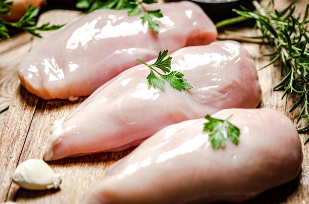 Photo filet de poulet frais avec des épices sur une table en bois