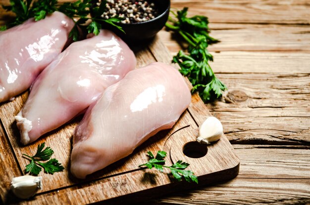 Photo filet de poulet frais avec des épices sur une table en bois