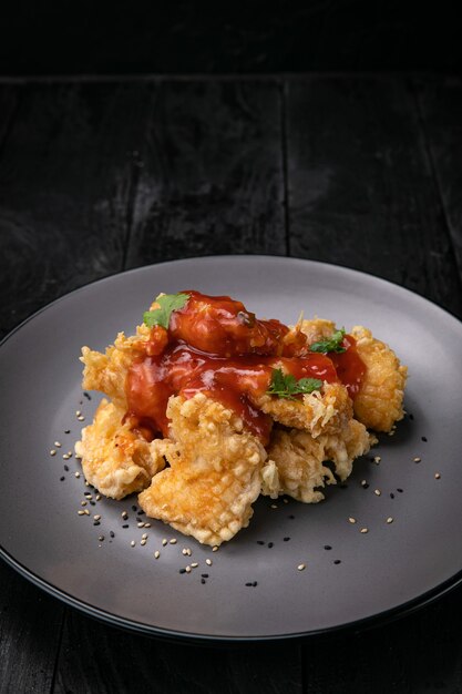 filet de poulet grillé avec sauce sur fond sombre