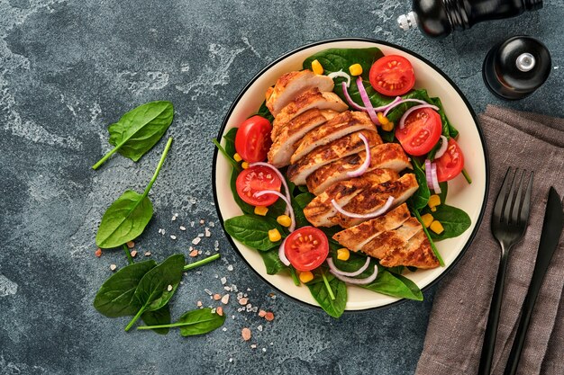 Filet de poulet avec salade d'épinards, tomates cerises, bleuet et oignon