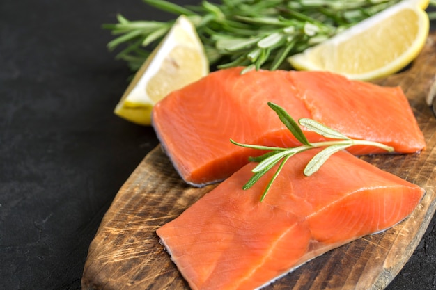 Photo filet de saumon de l'atlantique cru. sur une planche à découper en bois.