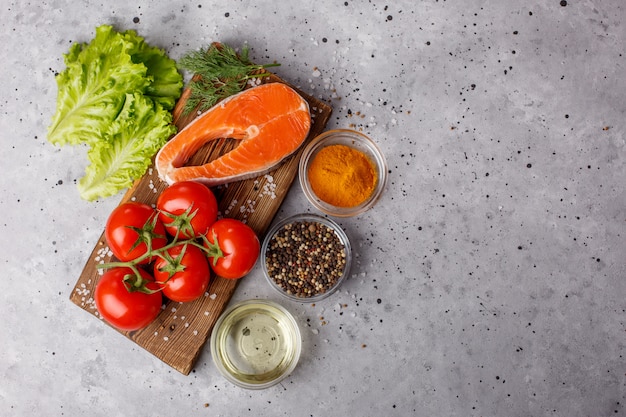 Filet de saumon aux épices et légumes sur un espace gris. Éducation culinaire. Espace alimentaire. Un équilibre alimentaire sain. Menu de l'espace table. Une copie de l'espace.