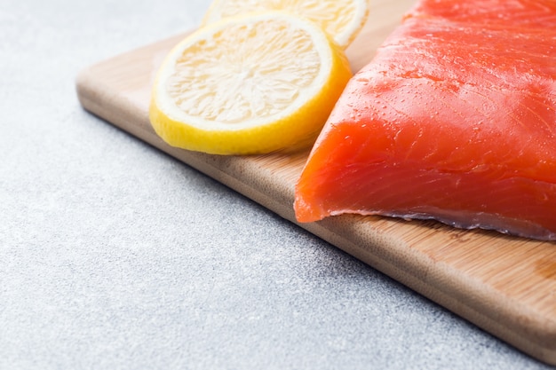 Photo filet de saumon frais au citron sur une planche à découper. espace de copie