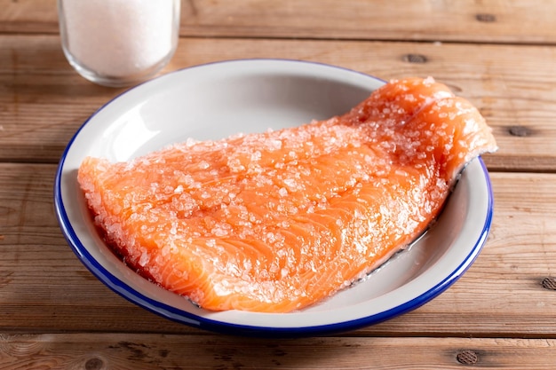 Filet de saumon frais avec du sel sur une assiette sur une table