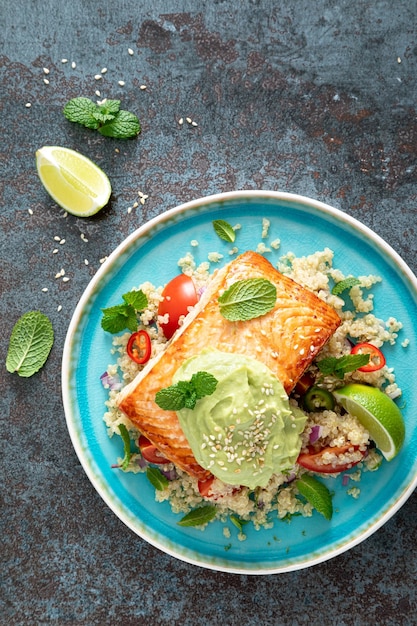 Filet de saumon grillé quinoa salade de légumes frais avec guacamole de tomate et d'avocat Vue de dessus