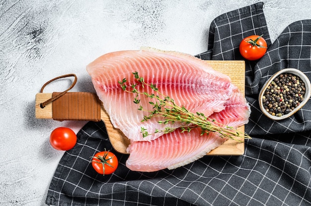 Filet de tilapia cru sur une planche à découper