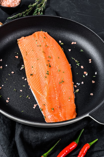 Filet de truite cru avec sel et piment dans une poêle. Poisson biologique. Vue de dessus.