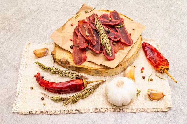 Filet de viande de boeuf séché avec mélange de romarin et de poivre sec, de piment et d'ail sur un linge en lin vintage