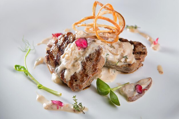 Filet de viande juteuse avec sauce aux champignons sur plaque blanche