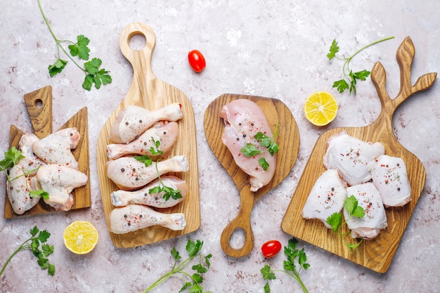 Filet de viande de poulet cru, cuisse, ailes et pattes aux herbes, épices, citron et ail. Vue de dessus