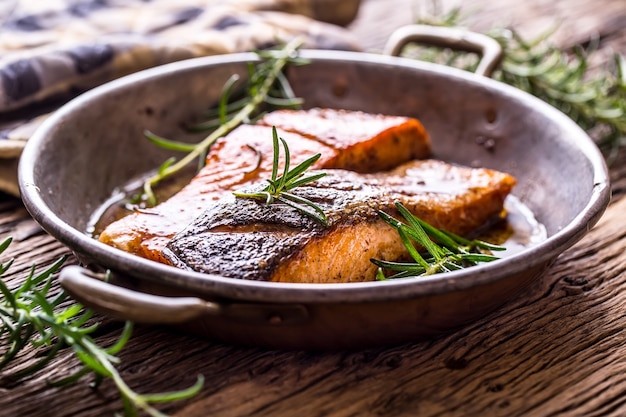 Filets de saumon grillés aux herbes de romarin dans une vieille poêle