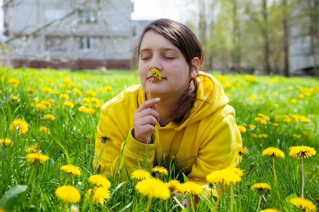 Fille de 12 ans dans les pissenlits le jour du printemps