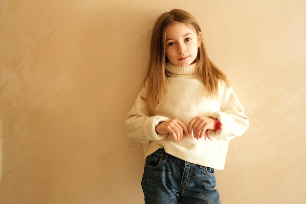 fille de 9 ans aux cheveux longs écolière modèle à la maison sur un portrait de fond beige