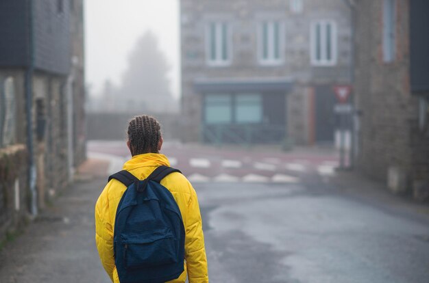 Une fille de 9 ans avec un sac à dos va à l'école le long d'une route de campagne le matin seule au printemps