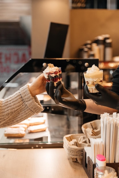 La fille achète le dessert dans un café