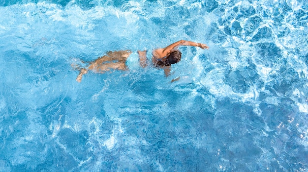 Photo fille active dans la piscine vue aérienne du drone d'en haut jeune femme nage dans l'eau bleue