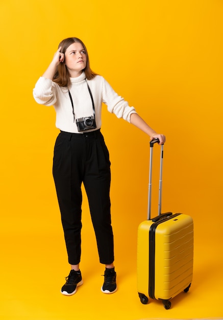 fille adolescent voyageur avec valise ayant des doutes et avec une expression confuse