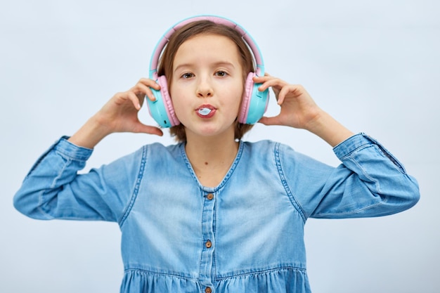 Fille adolescente avec chewing-gum écoutant de la musique dans des écouteurs