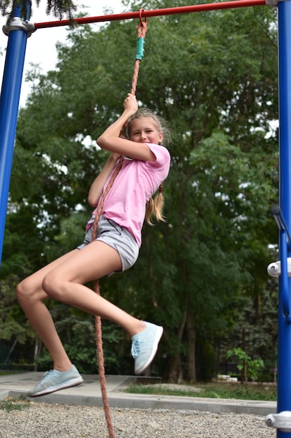 Fille adolescente gymnaste caucasienne sur aire de jeux extérieure sports pour enfants pour la santé