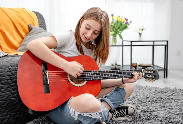 Fille adolescente pratiquant le jeu de guitare