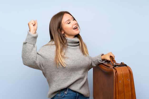 Fille adolescente avec pull tenant une mallette vintage