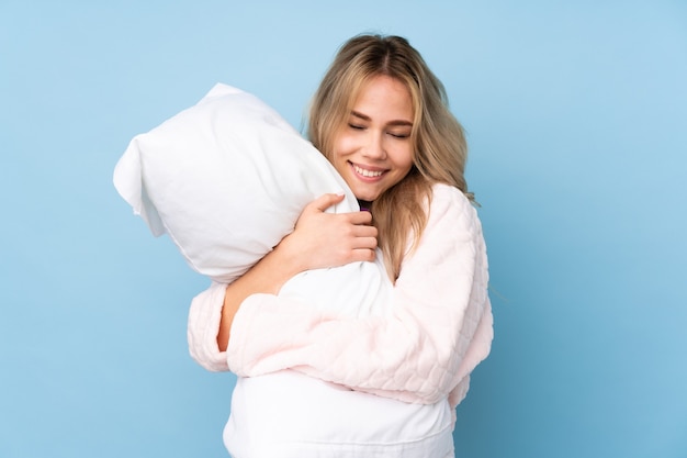 Fille adolescente en pyjama isolé sur bleu