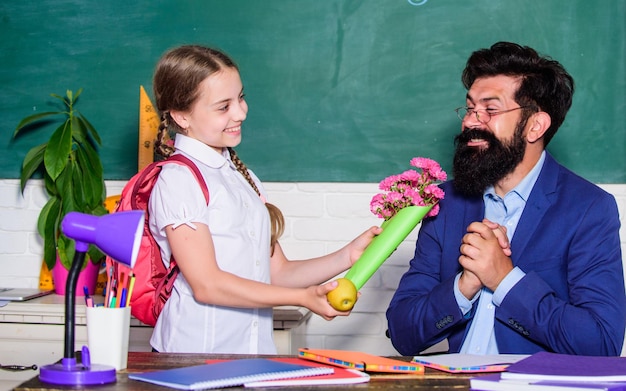 Fille adorable élève avec sac à dos donnant bouquet de fleurs professeur Retour à l'école Meilleurs voeux Félicitations pour la journée de la connaissance Salutations pour le pédagogue scolaire Vacances scolaires Écolière reconnaissante