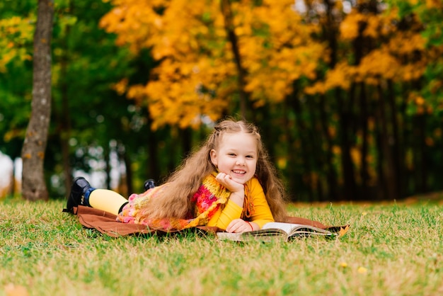 Fille adorable d'enfant à un beau parc d'automne