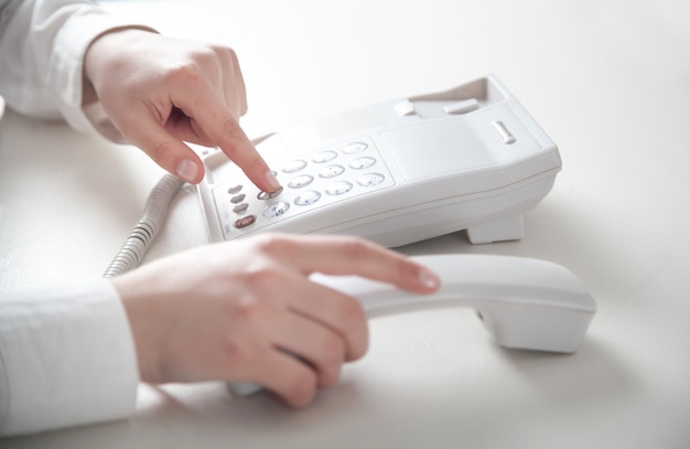 Fille d'affaires appelant au téléphone de bureau.