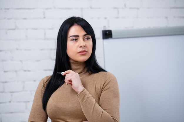 Fille d'affaires, enseignante, formatrice enseigne et parle d'un nouveau projet debout près du tableau noir