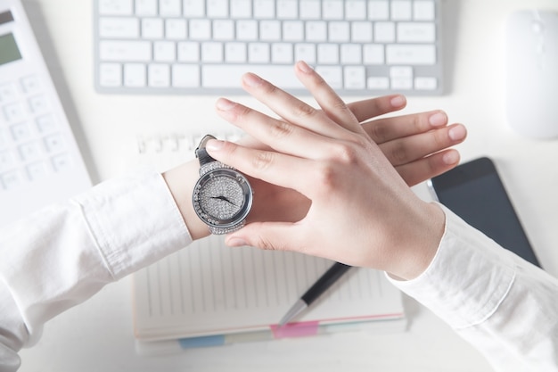 Fille d'affaires fixant sa montre-bracelet.