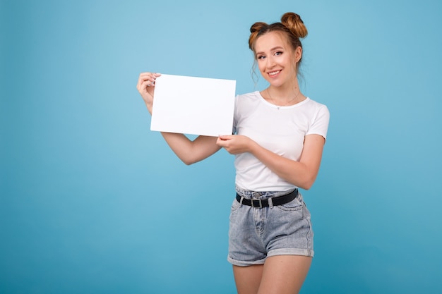 Fille avec une affiche blanche sur un espace bleu