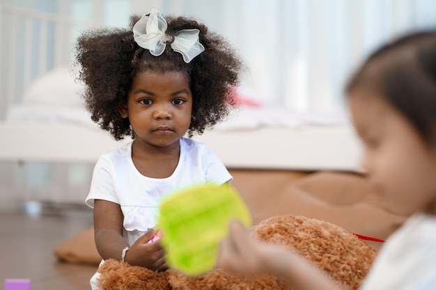 Photo fille africaine amusez-vous à jouer avec les amis de votre enfant dans le salon