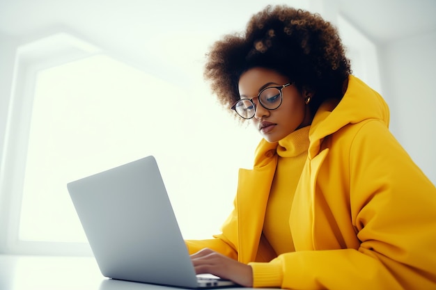 Une fille africaine avec une coiffure luxuriante dans une veste jaune est assise devant un cahier de travail à distance ai génératif