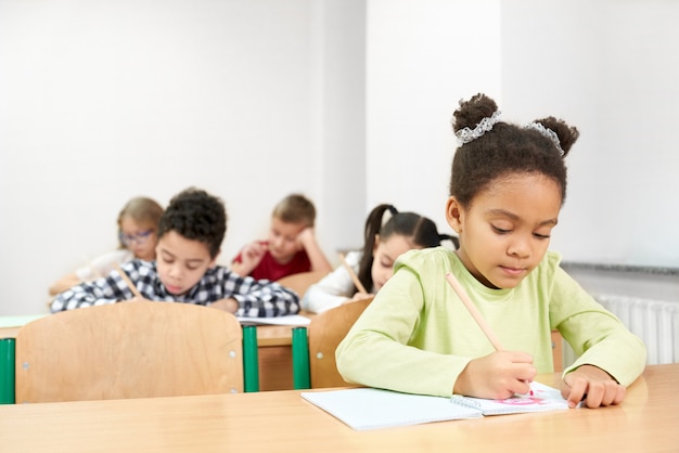 Fille africaine sérieuse en train d'étudier à l'école