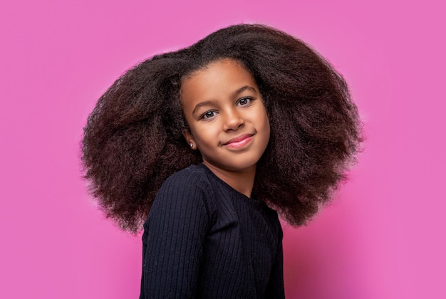 Une fille africaine souriante Souriez une petite fille afro-américaine Une jeune fille africaine américaine Souriez et vos cheveux bouclés Riez un joli portrait de jeune fille afro Une petite fille mignonne souriante