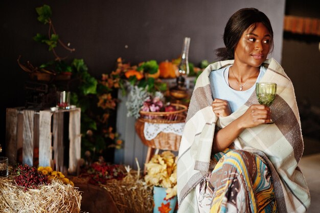 Fille afro-américaine assise sur une chaise berçante contre la décoration d'ambiance d'automne Automne en Afrique