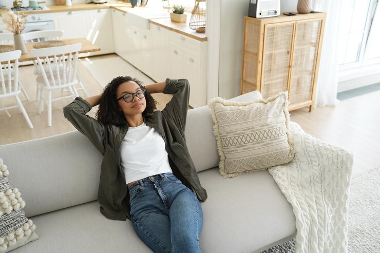 Photo une fille afro-américaine calme profite de l'air frais et climatisé en se reposant sur un canapé confortable dans le salon