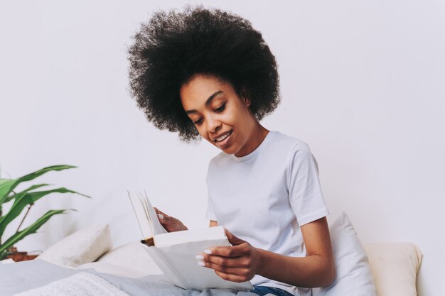 Photo fille afro-américaine se reposant dans son lit à la maison - belle femme se reposant à la maison