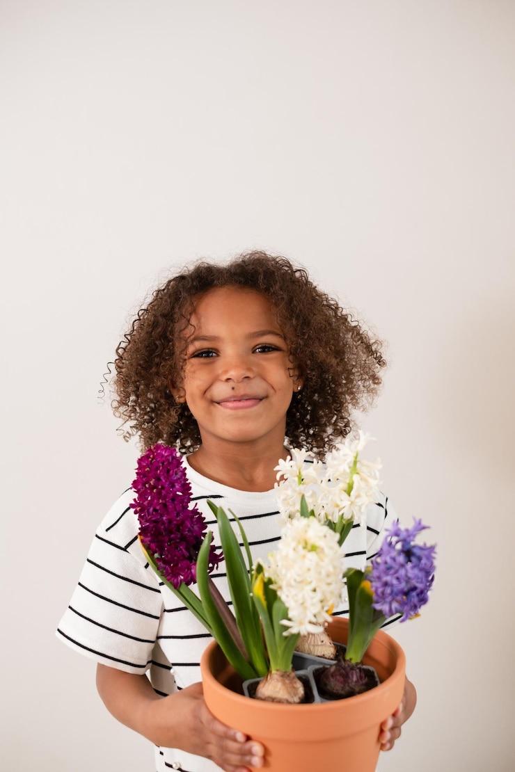 Photo une fille afro-américaine souriante avec des boucles rebondissantes présente un pot de jacinthes vibrants un cadeau sincère de la fête des mères symbolisant la gratitude et l'amour