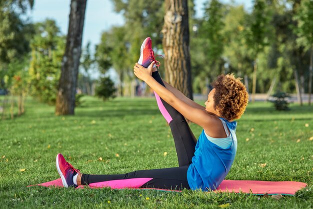 Fille afro-américaine sportive faisant de l'exercice dans le parc