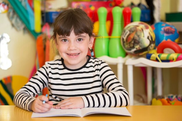 Fille d'âge préscolaire avec un livre Première année Élève du primaire avec un cahier