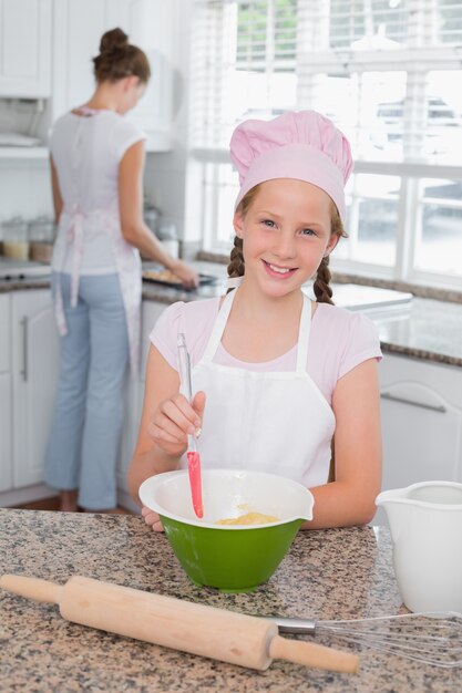 Fille aidant sa mère à préparer la nourriture dans la cuisine