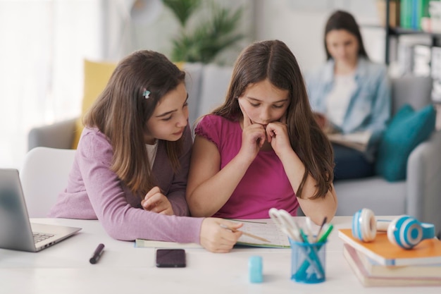 Fille aidant sa sœur cadette à faire ses devoirs