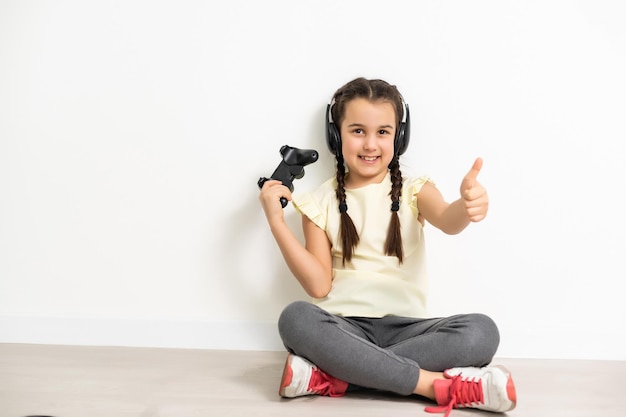 Fille à l'aide du contrôleur de jeu vidéo isolé sur fond blanc.