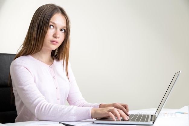 Fille à l'aide du côté de l'ordinateur portable