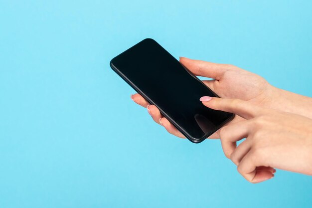 Photo fille à l'aide de smartphone sur fond bleu