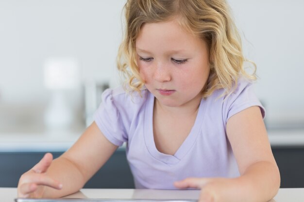 Fille à l&#39;aide de tablette numérique à table