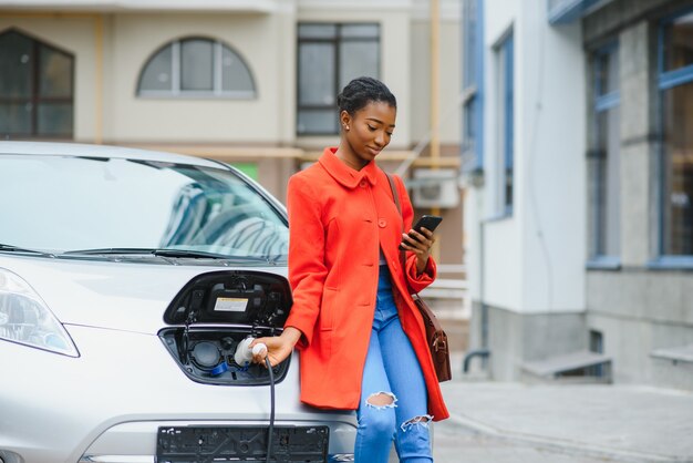 Fille américaine debout près de la voiture.